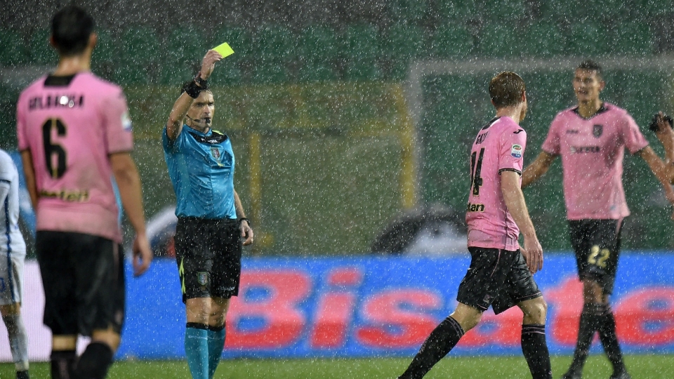 Referee Massimiliano Irrati shows a yellow card as Inter face Palermo in torrid conditions InterPalermo - cropped